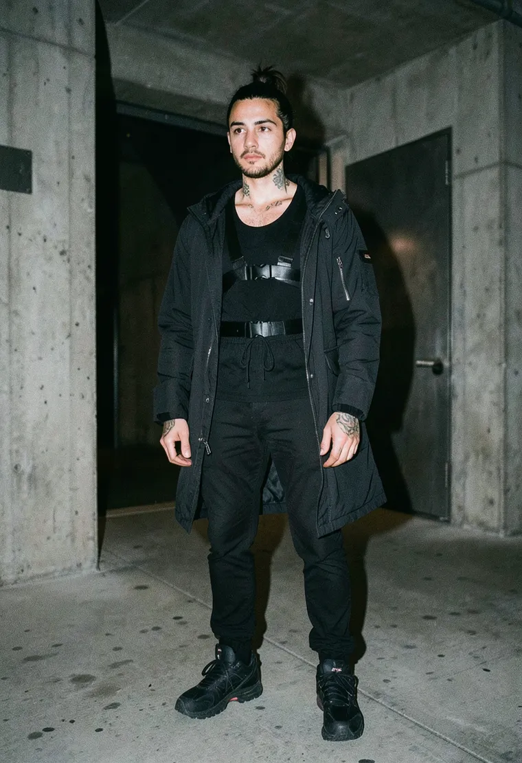 mid-30s Berlin-based Turkish techno producer, gender-nonconforming, serene and deeply focused energy, visible tattoos on neck and hands.