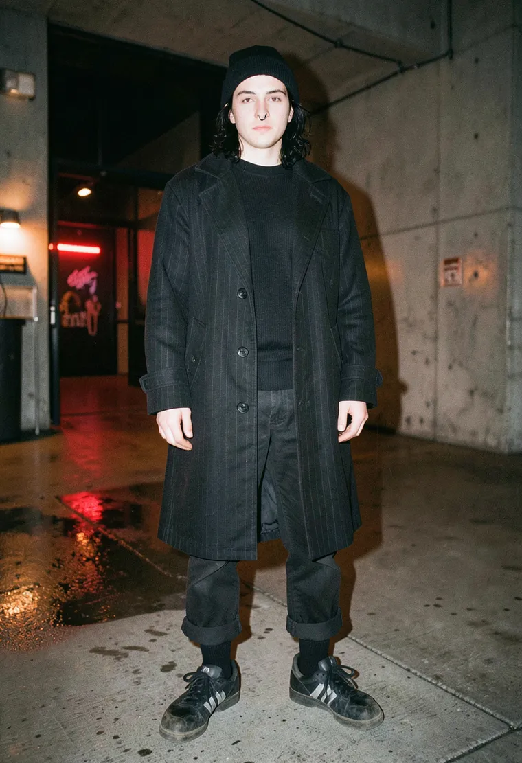 28-year-old non-binary Romanian-Berliner with the quiet intensity of a warehouse techno veteran, hair slightly greasy from dancing all week, eyes half-lidded from last night’s afterparty.