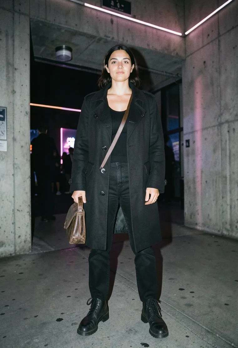 A 38-year-old non-binary Berliner of South African and German descent, carrying the weary confidence of someone who has been in the scene since the rave scene was cool, currently wearing a thrifted military coat.